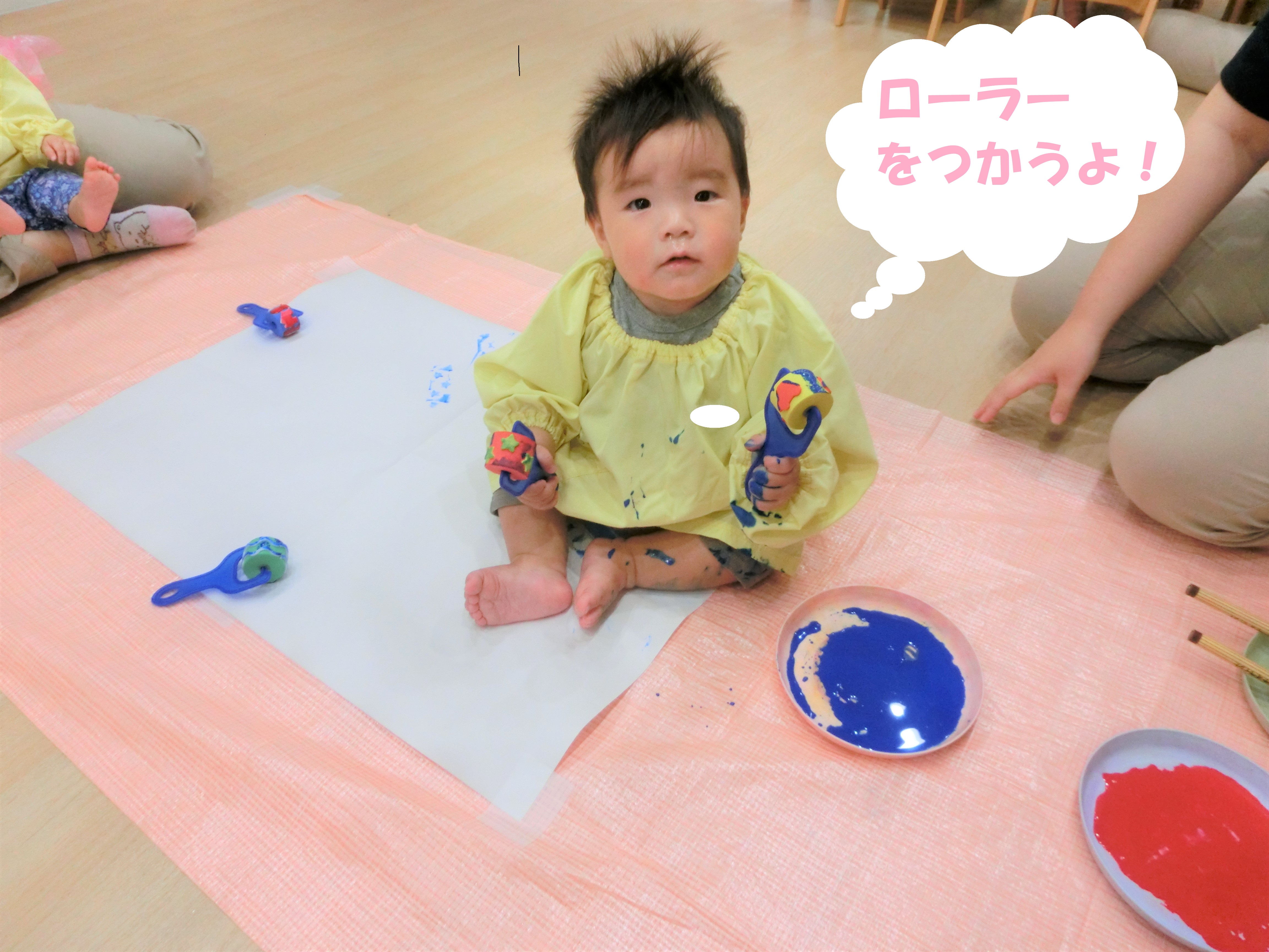大きな<span style='color:#70b7ff;'>模造紙</span>と、<span style='color:#6bb5ff;'>ローラー</span>を用意して<br>絵の具遊びをしました<span style='color:#75ffff;'>(^^♪</span><br><br>「<span style='color:#b5ff6b;'>なんだろう？</span>」と興味を持って<br>ローラーを手にする子どもたち、<br>初めは先生と一緒に握って<br><span style='color:#ff70ff;'>色を付けて</span>楽しみました<span style='color:#ffb770;'>(^^♪</span><br><br>慣れてくると、<br>自分で<span style='color:#ff70b7;'>色を付けて</span>紙に<span style='color:#ff70b7;'>ころころ♪</span>