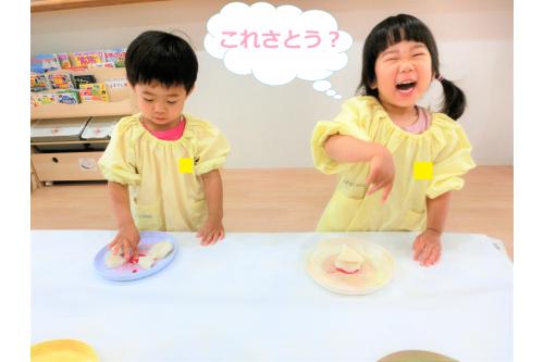 「今日は絵の具遊びをするよ！なに色がいい？」<br>と1人ずつ好きな色を選んでお皿の中へ<span style='color:#ffb770;'>(^^)</span><br>絵の具ともう一つ先生が<br>お皿の中に<span style='color:#ff7575;'>あるもの</span>をいれると…<br><br>「なにこれ！<span style='color:#ff7aff;'>さとう</span>かな？」<br>と不思議そうな子どもたち。<br><span style='color:#70ff70;'>ツンツン</span>とつついてみたり<br><span style='color:#75baff;'>クンクン</span>とにおいを嗅いだりして<br>確認していました<span style='color:#ffbc7a;'>!(^^)!</span>