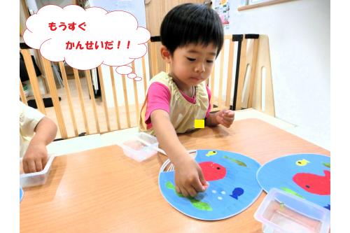<span style='color:#ff0000;'>お魚</span>の色が乾いたら<span style='color:#bc7aff;'>丸い<br>シール</span>を貼って完成<span style='color:#ff7f00;'>！！</span><br><br><span style='color:#ffba75;'>パタパタ</span>とあおいで<br>「きもち～」「せんせいにもしてあげる！」<br>と<span style='color:#7abcff;'>心地よい風</span>をおくってくれました(<span style='color:#ff00ff;'>*</span>^^<span style='color:#ff00ff;'>*</span>)<br>