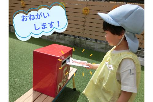 お手紙を届けるためには<span style='color:#00ff00;'>ポストに入れる</span>んだよと<br>お話をして早速<span style='color:#ff0000;'>園庭に設置されたポスト</span>へ。<br><br><span style='color:#7f00ff;'>「ポストのお口にお手紙入れてね」</span>とお話すると<br>上手に<span style='color:#ff7f00;'>入れること</span>ができました！<br>