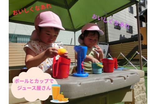 こちらは<span style='color:#ff007f;'>カウンター</span>や<span style='color:#00ff00;'>流し台</span>、<span style='color:#ff7f00;'>BBQグリル</span>まである<br>キッチンセット！<br><br><span style='color:#007fff;'>うさぎチーム（２歳児）</span>はここでお店屋さんごっこを<br>楽しみました<span style='color:#00ffff;'>♪</span><br><span style='color:#7f00ff;'>「何ジュースにしますか～？」</span><span style='color:#00ff00;'>「今作ってるからね！」</span>とお話しながらも<br>黙々と作業に取り組んでいました！<br><br>途中ほかのチームのお友だちが来ると<br><span style='color:#ff7f00;'>「このジュース甘いよ！」</span>と<br>お裾分けしてくれる姿も<span style='color:#ff0000;'>♡</span>