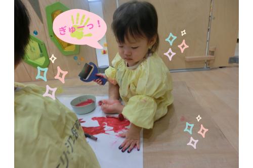 <span style='color:#7f00ff;'>先生のまねっこ</span>をして<br>手のひらに絵の具を塗り広げて…<br>